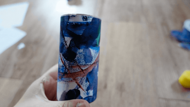 물감으로 색칠한 도화지를 휴지심에 감싸는 모습